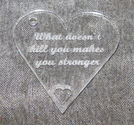 Plexiglas hänge hjärta 40mm *What doesn't kill you makes you stronger* 
